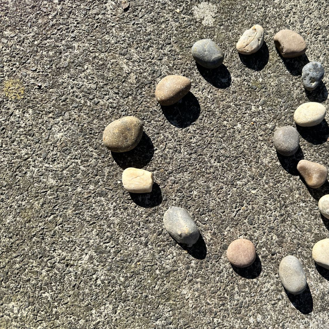 Piccole pietre che formano un cuore sulla sabbia di una spiaggia, simbolo di un incontro dopo i 50 anni, di una relazione duratura e dell’amore condiviso.
