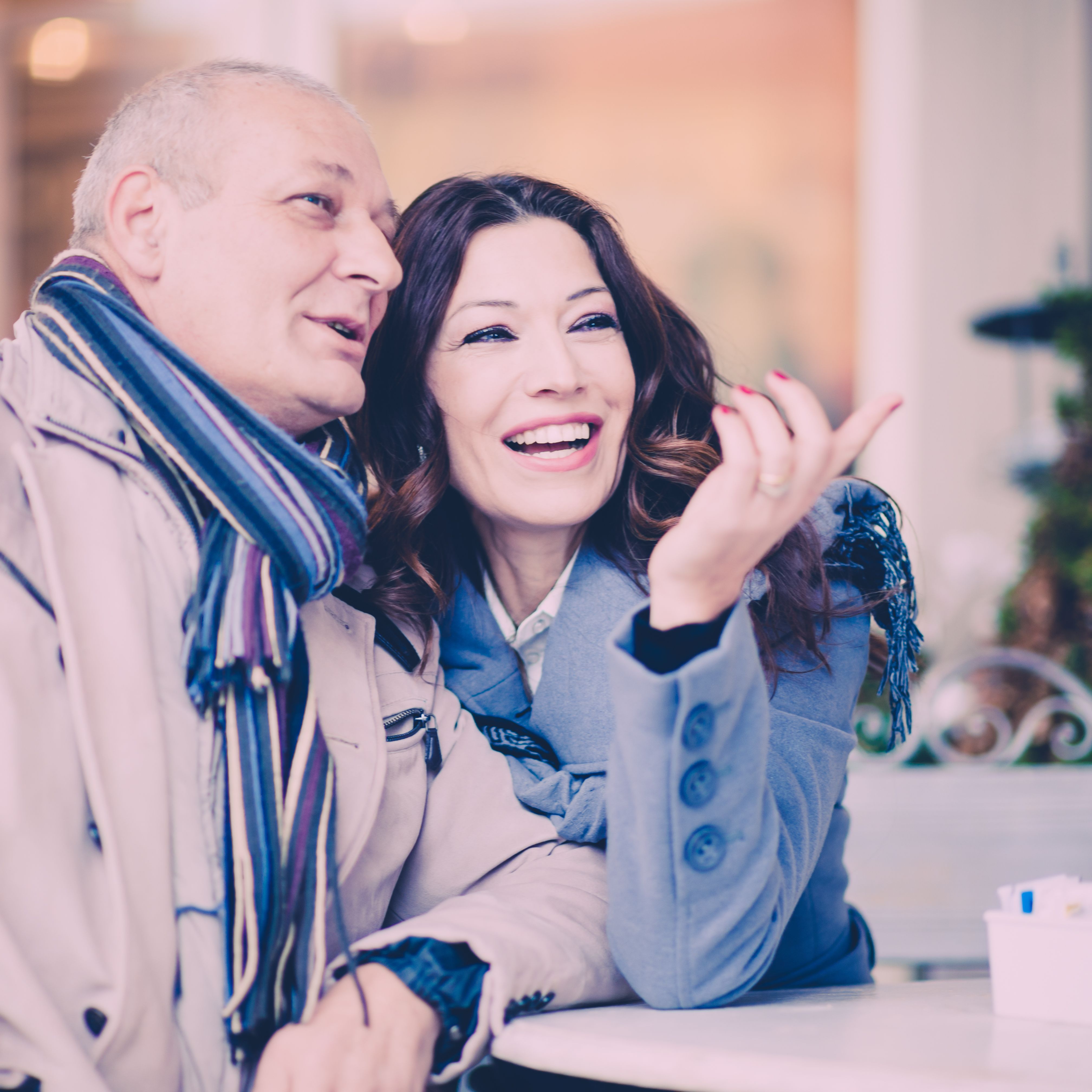 Uomo e donna sulla cinquantina che si scambiano un sorriso durante un primo appuntamento, a illustrare un incontro dopo un divorzio e l'inizio di una relazione seria.